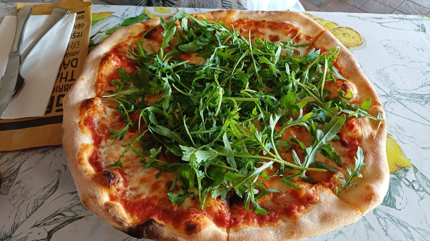 Pizza margherita con rucola appena uscita dal forno a legna