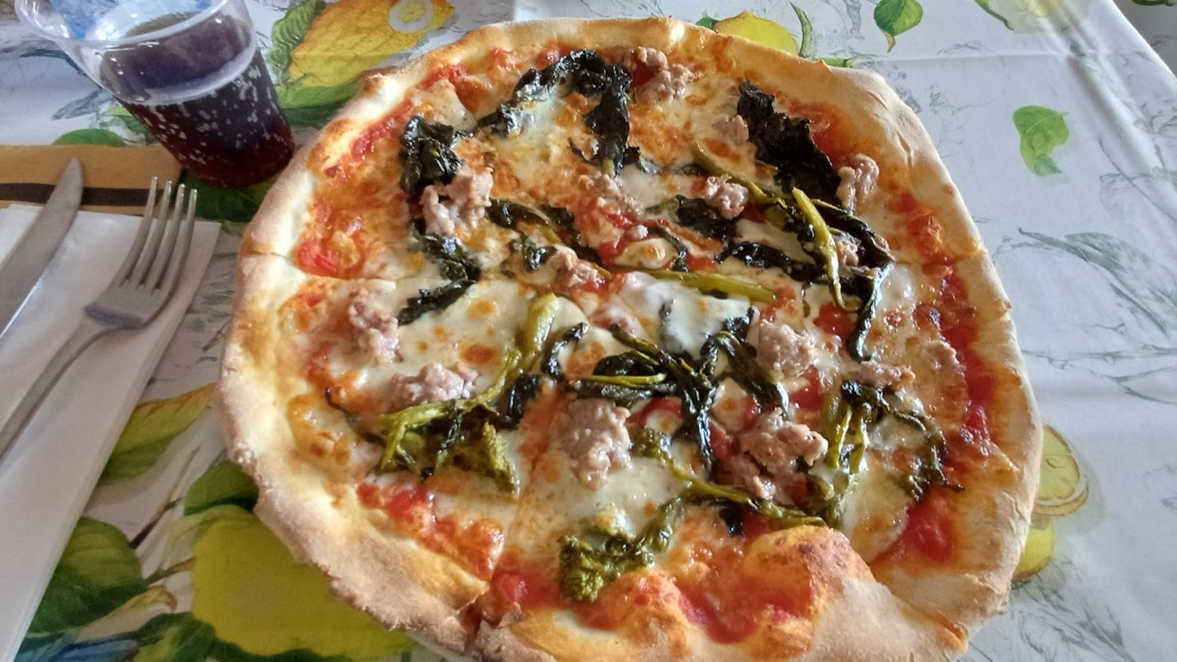 Pizza con salsiccia e verdure cotta nel forno a legna